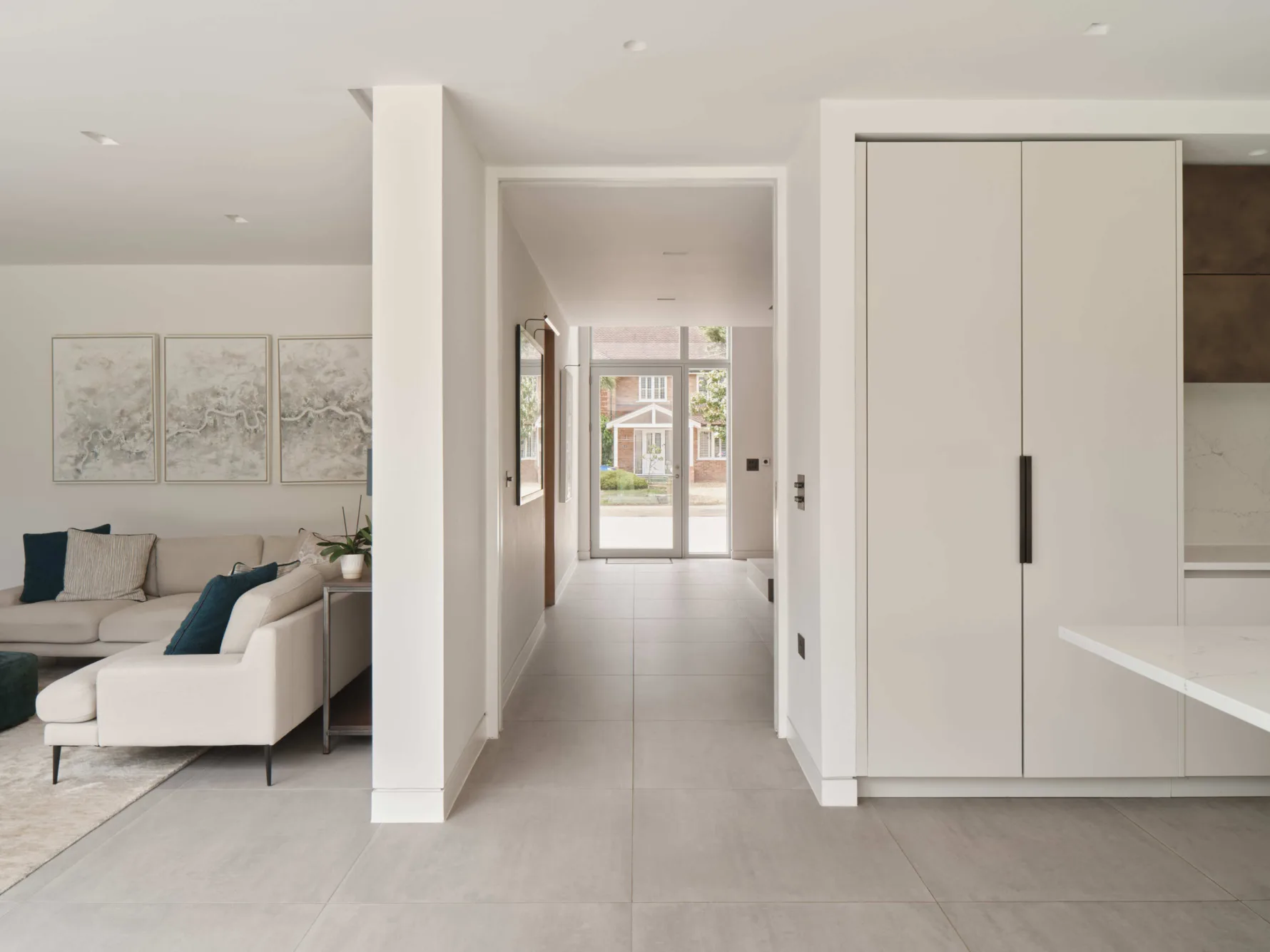 Sleek white and bright open plan contemporary lounge and kitchen