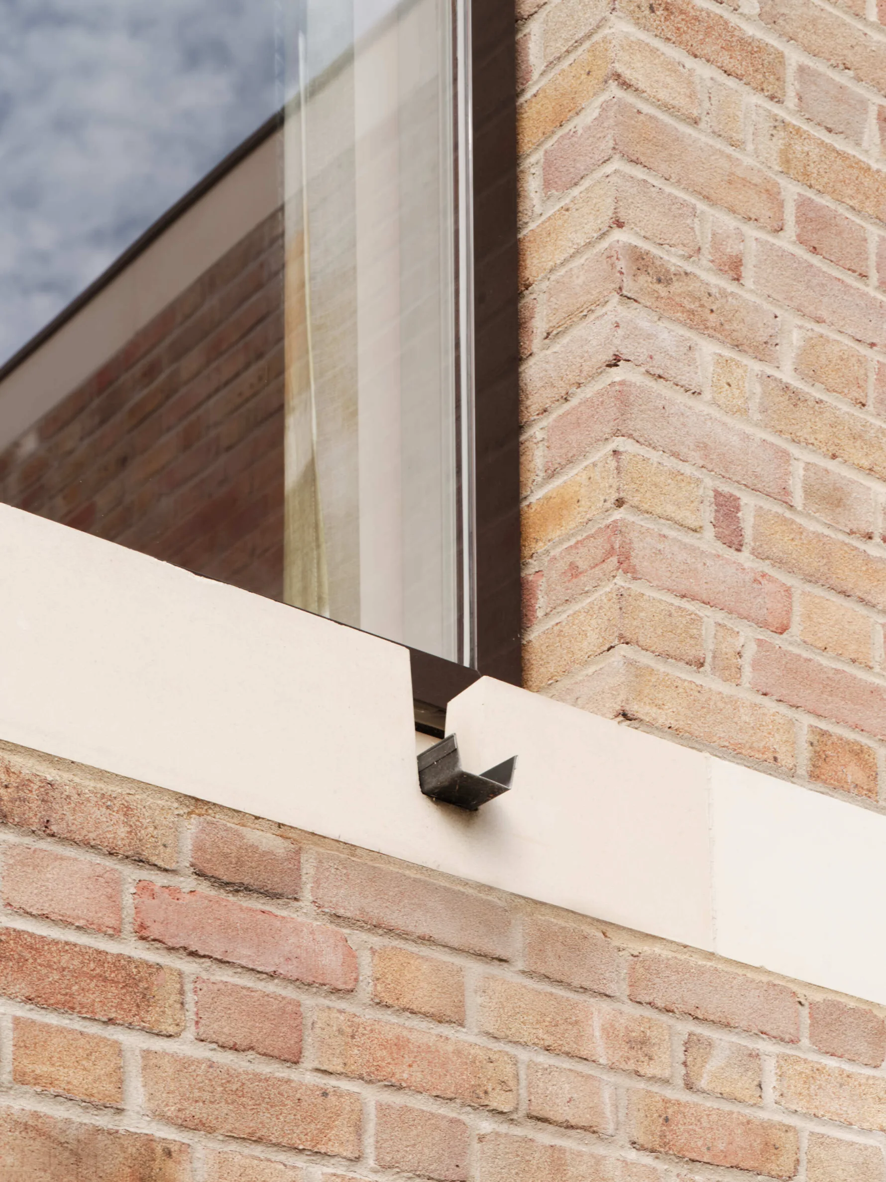 Close up photo of stone detail surrounding a window of new modern build