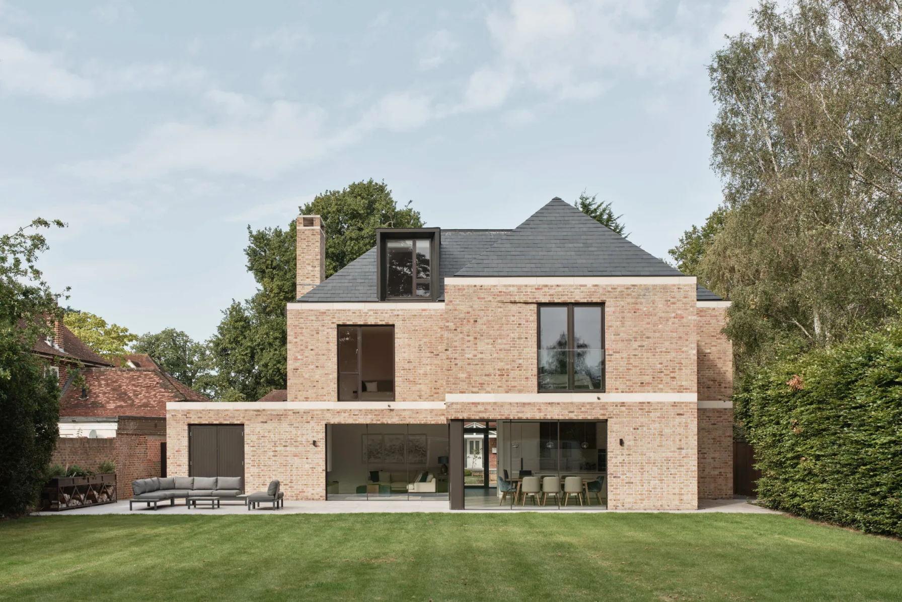 Rear elevation with large glass doors opening onto garden terrace