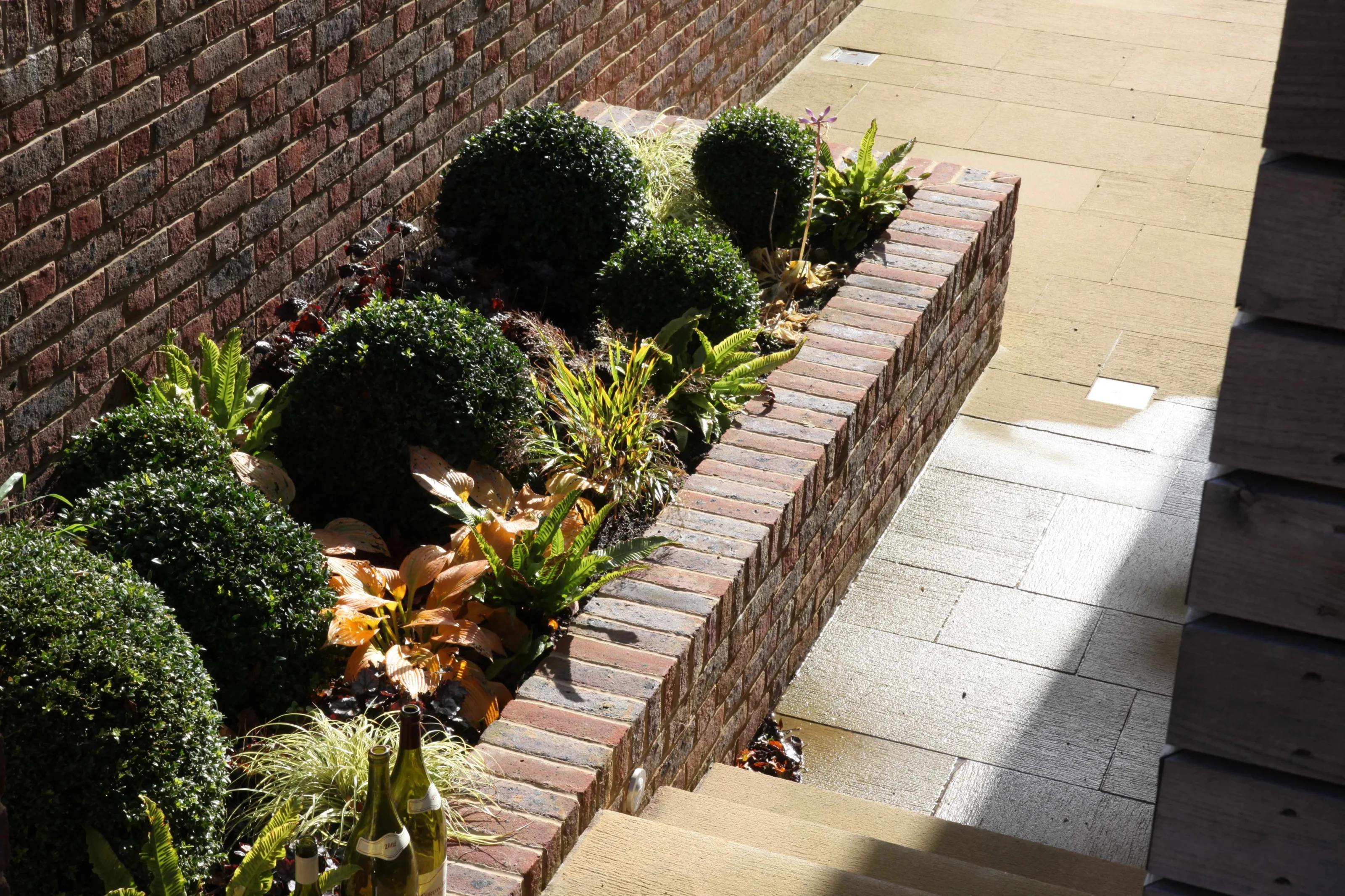Brick planter, stone paving and planting detail within the courtyard landscape at Guildford House.