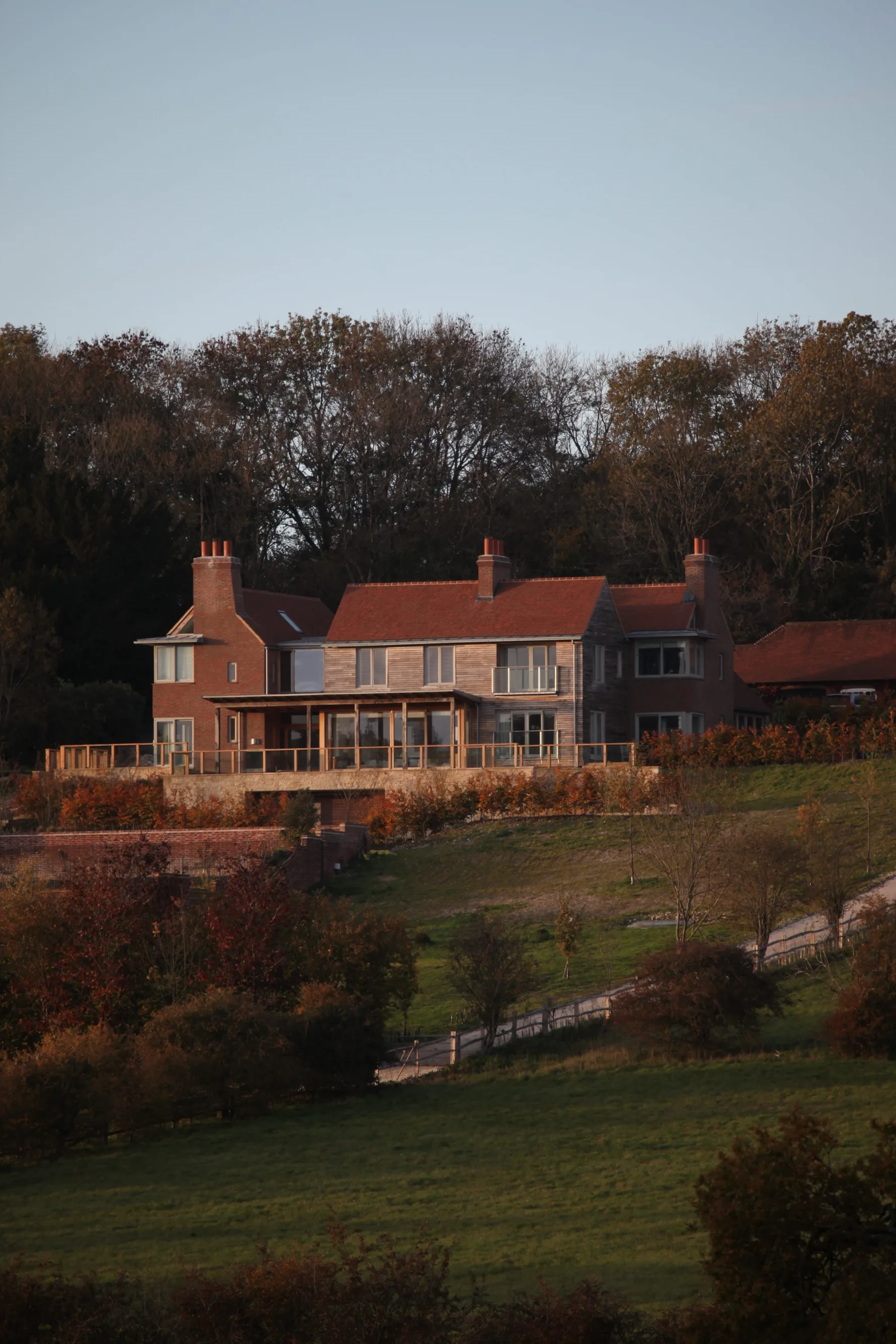 Guildford House, a contemporary rural dwelling combining brick, timber and traditional roof forms within a landscaped setting.