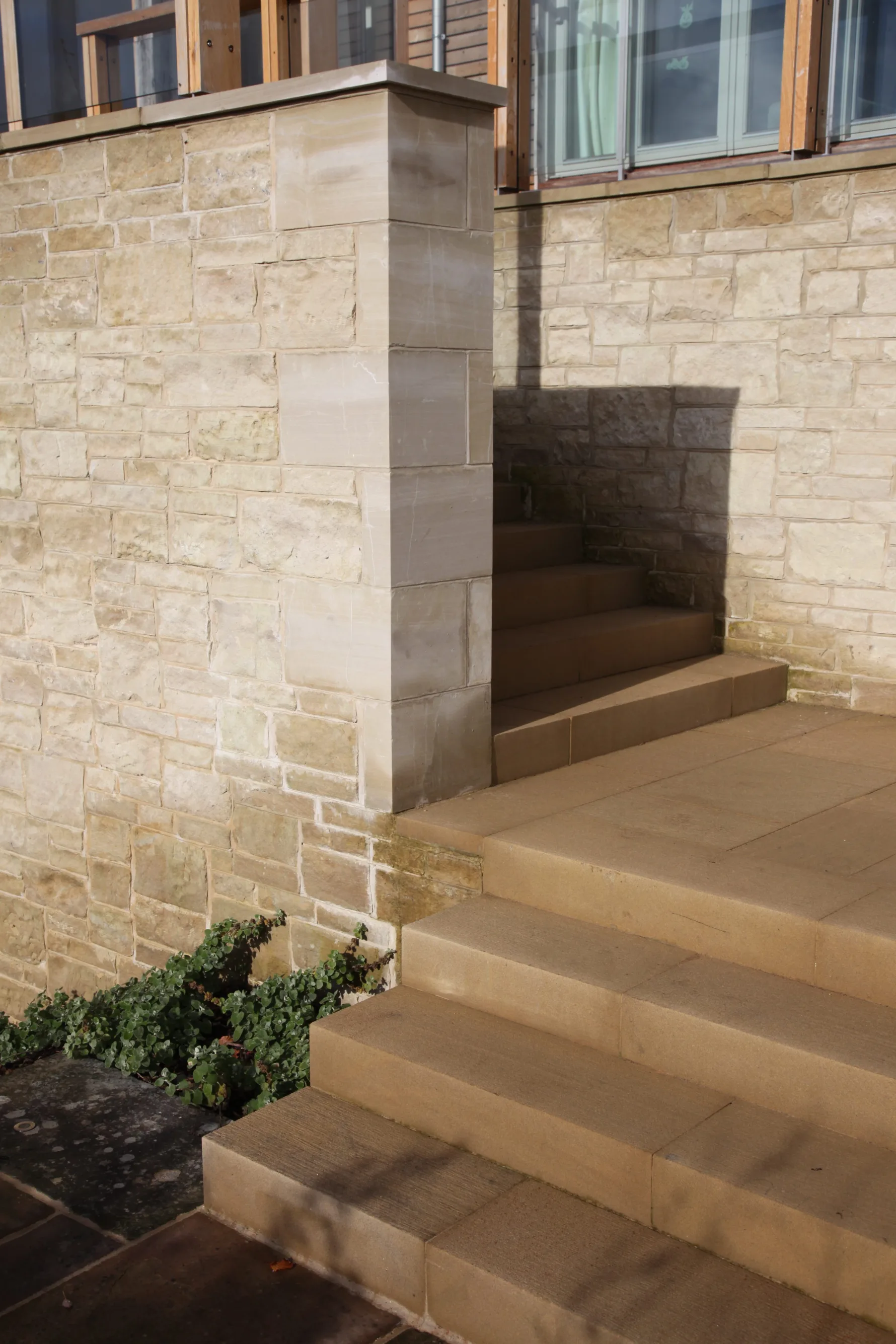 Sandstone retaining wall and external steps connecting the garden level to the elevated terrace at Guildford House.