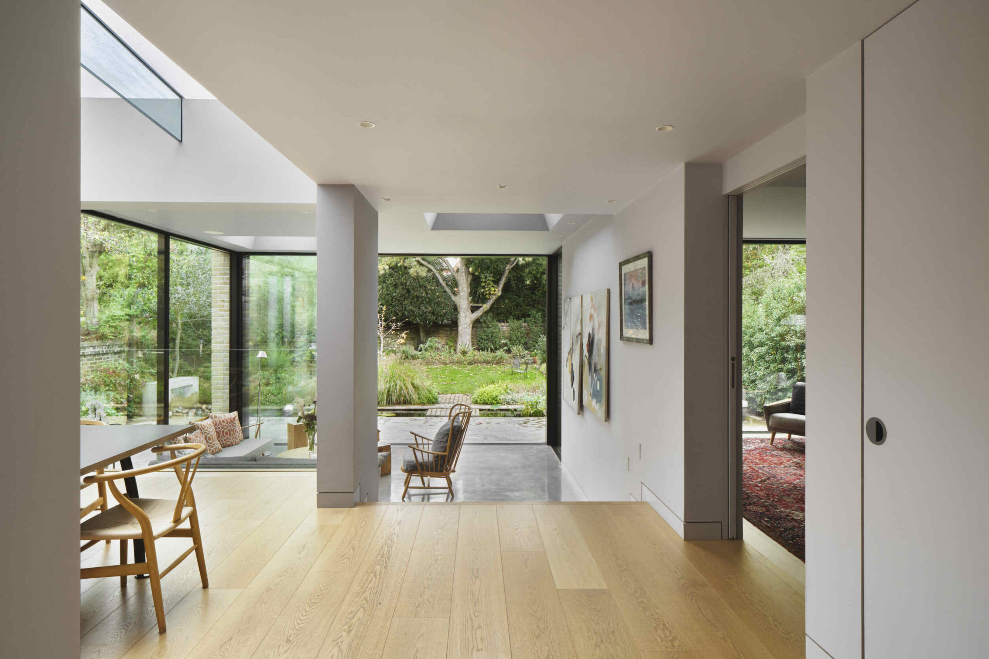 Open-plan extension at Kew House with views through the living spaces to the rear garden and extensive floor-to-ceiling glazing