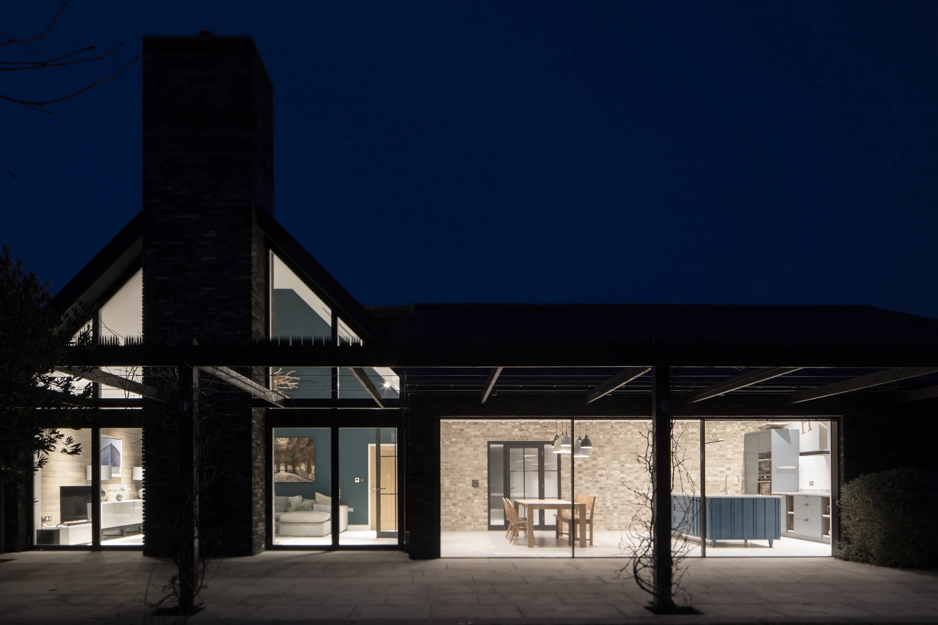 Detailed view of rear extension glazing showing open-plan kitchen and living space at night