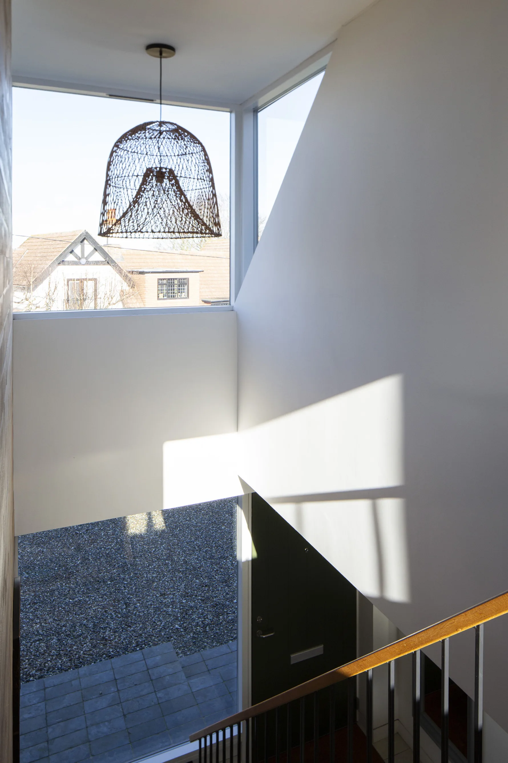 Double-height stair space with large window bringing natural light into contemporary interior