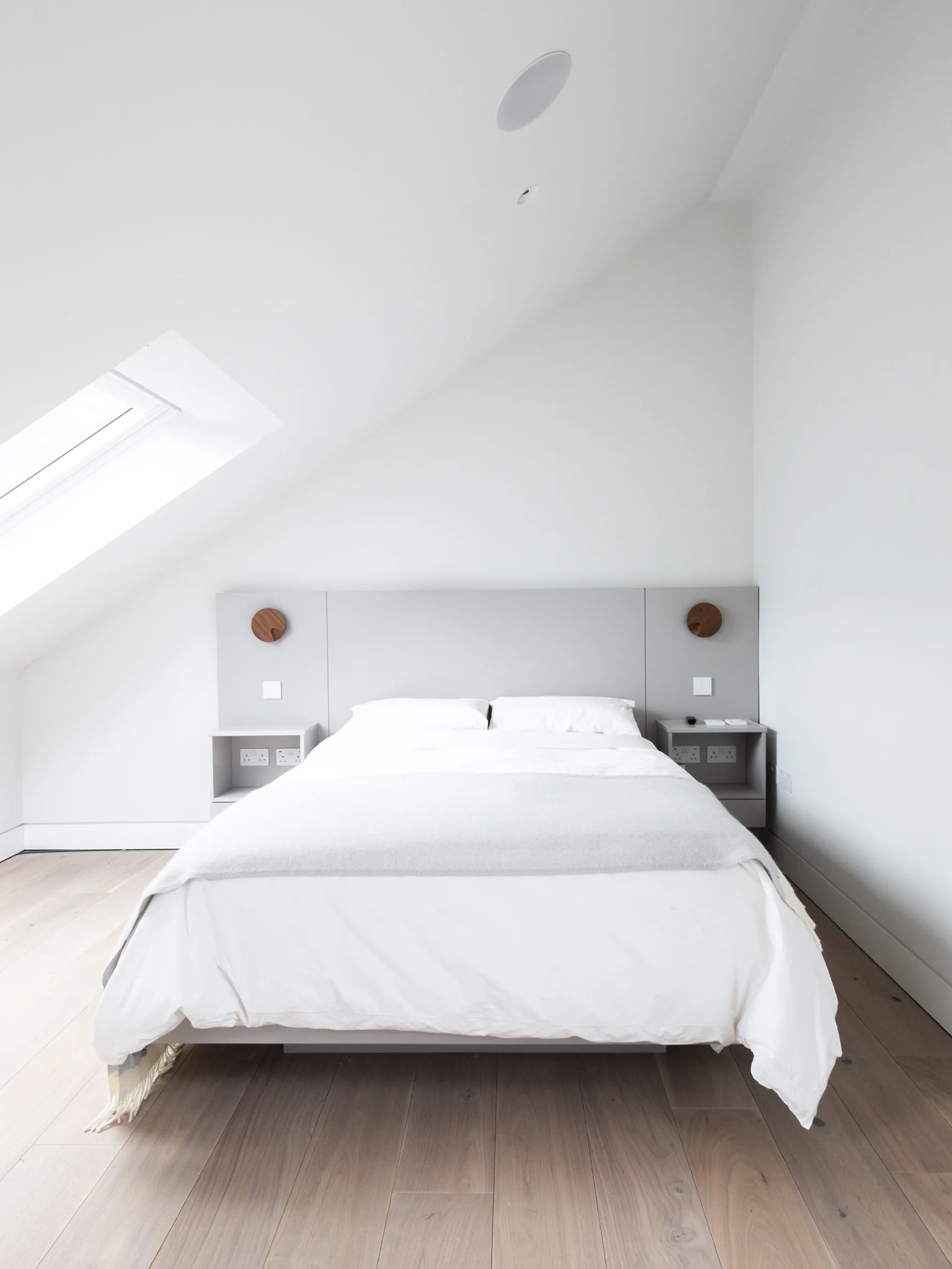 Minimalist master bedroom in Old Hunstanton new build with sloped ceiling, rooflight and timber flooring