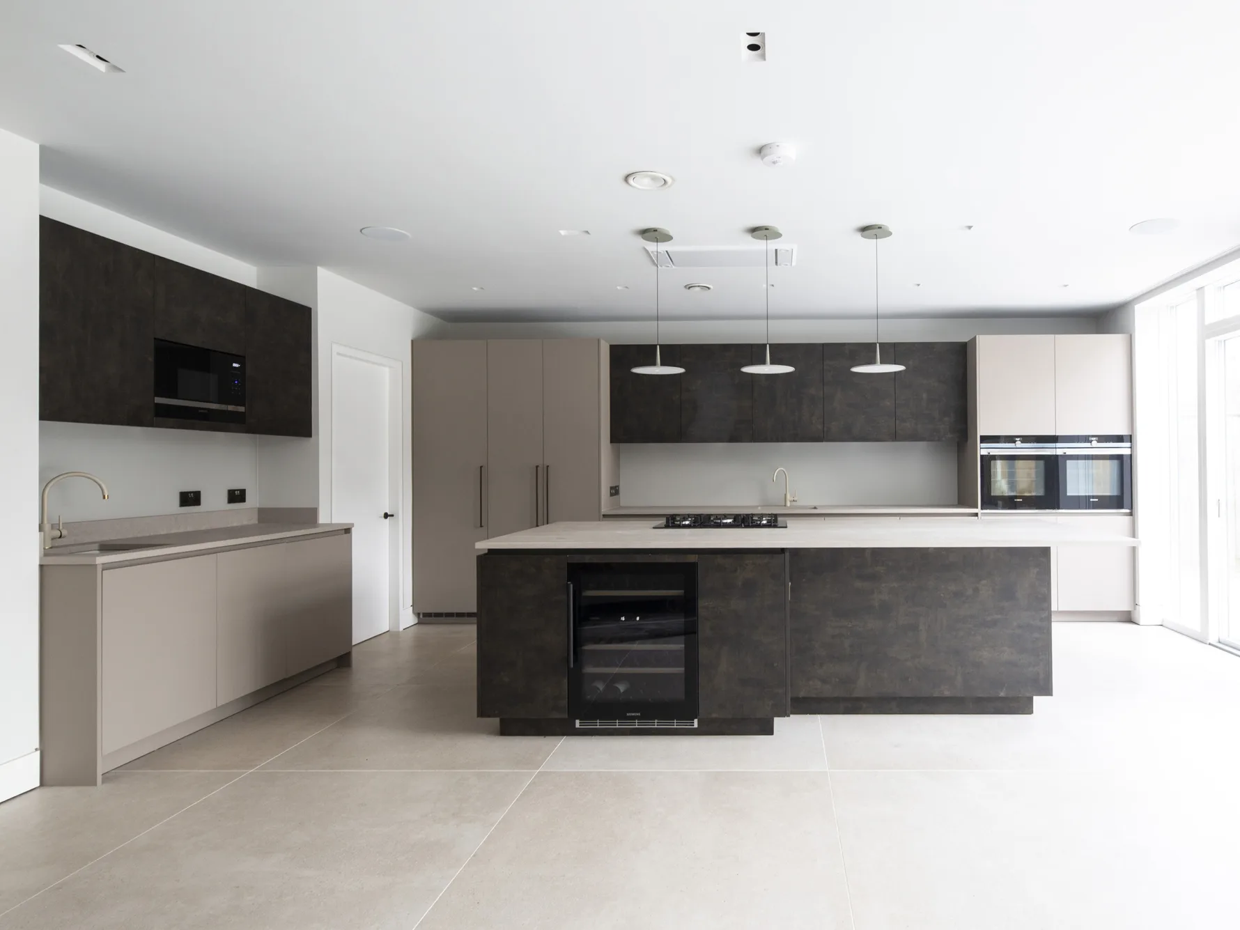 Contemporary kitchen with island, handleless units and integrated appliances in architect-designed UK home