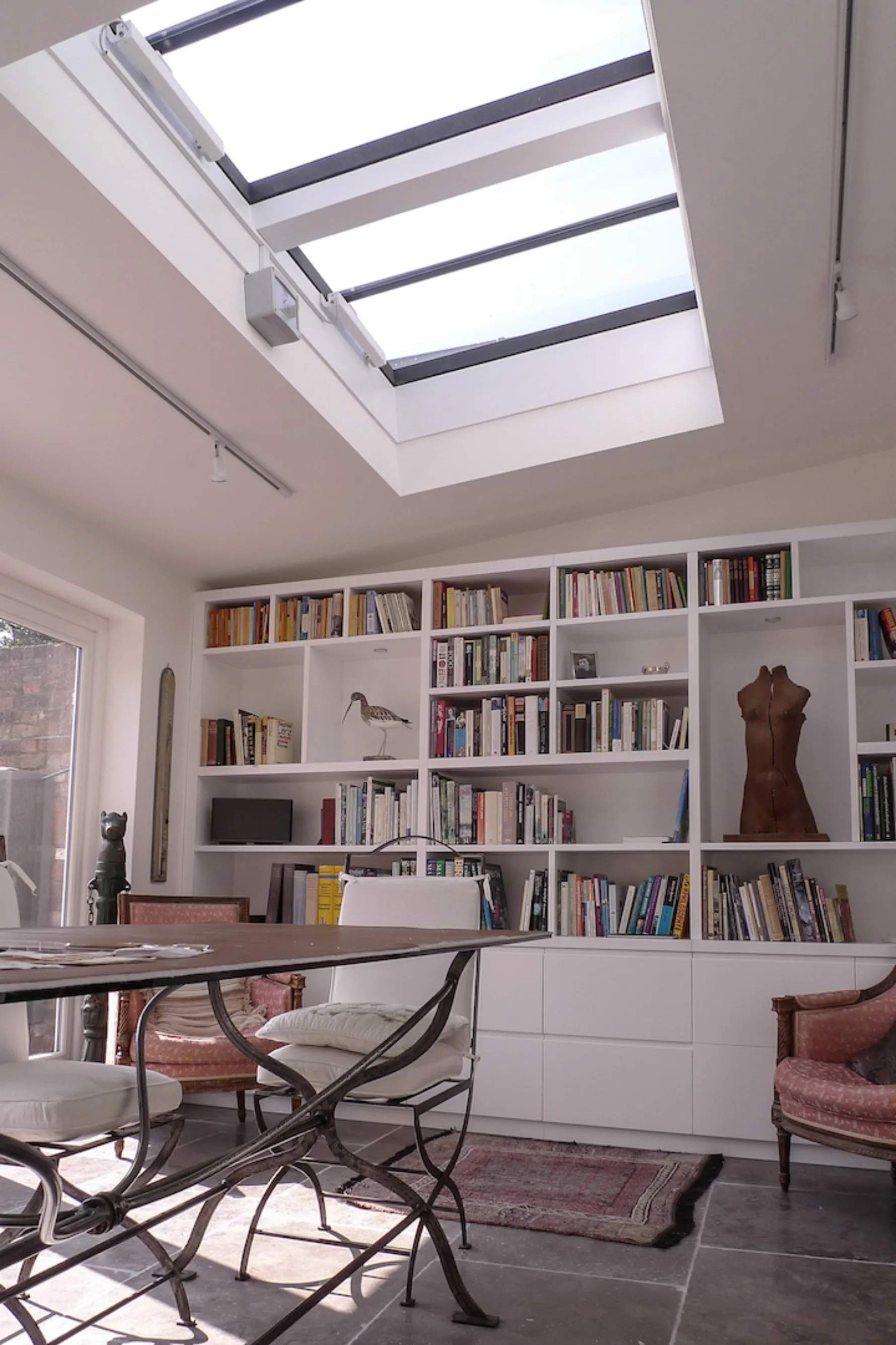 Contemporary kitchen extension at Thames Ditton House 04 with large rooflights, bespoke bookcases and an open-plan living space