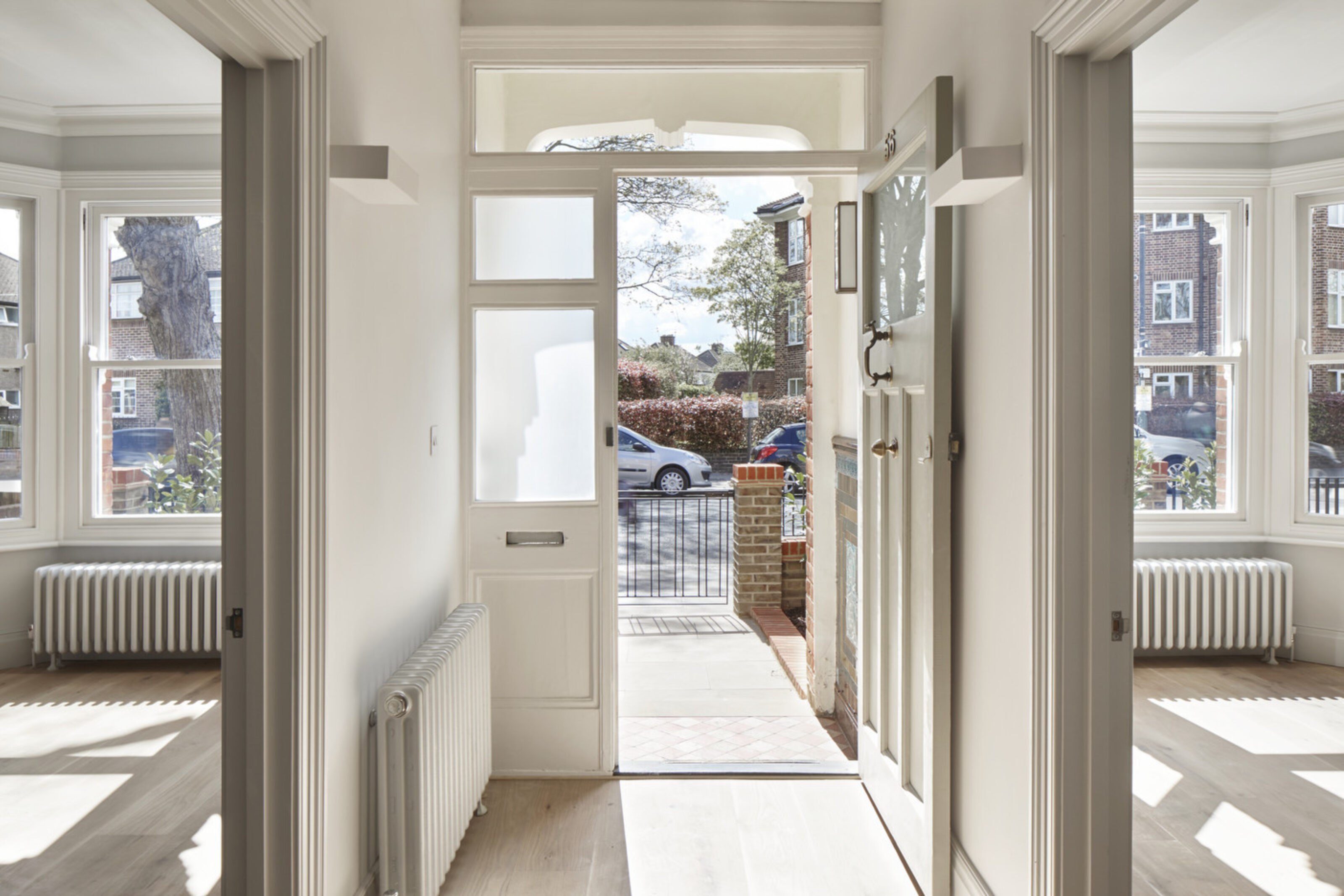 Bright entrance hallway at Twickenham House with period features, large windows and contemporary refurbishment.