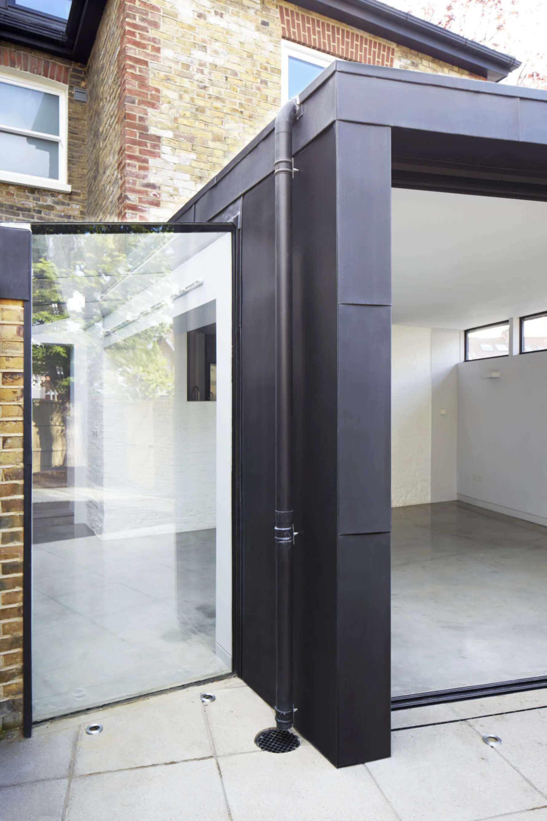 Contemporary rear extension at Twickenham House featuring zinc cladding, frameless corner glazing and bespoke architectural detailing.
