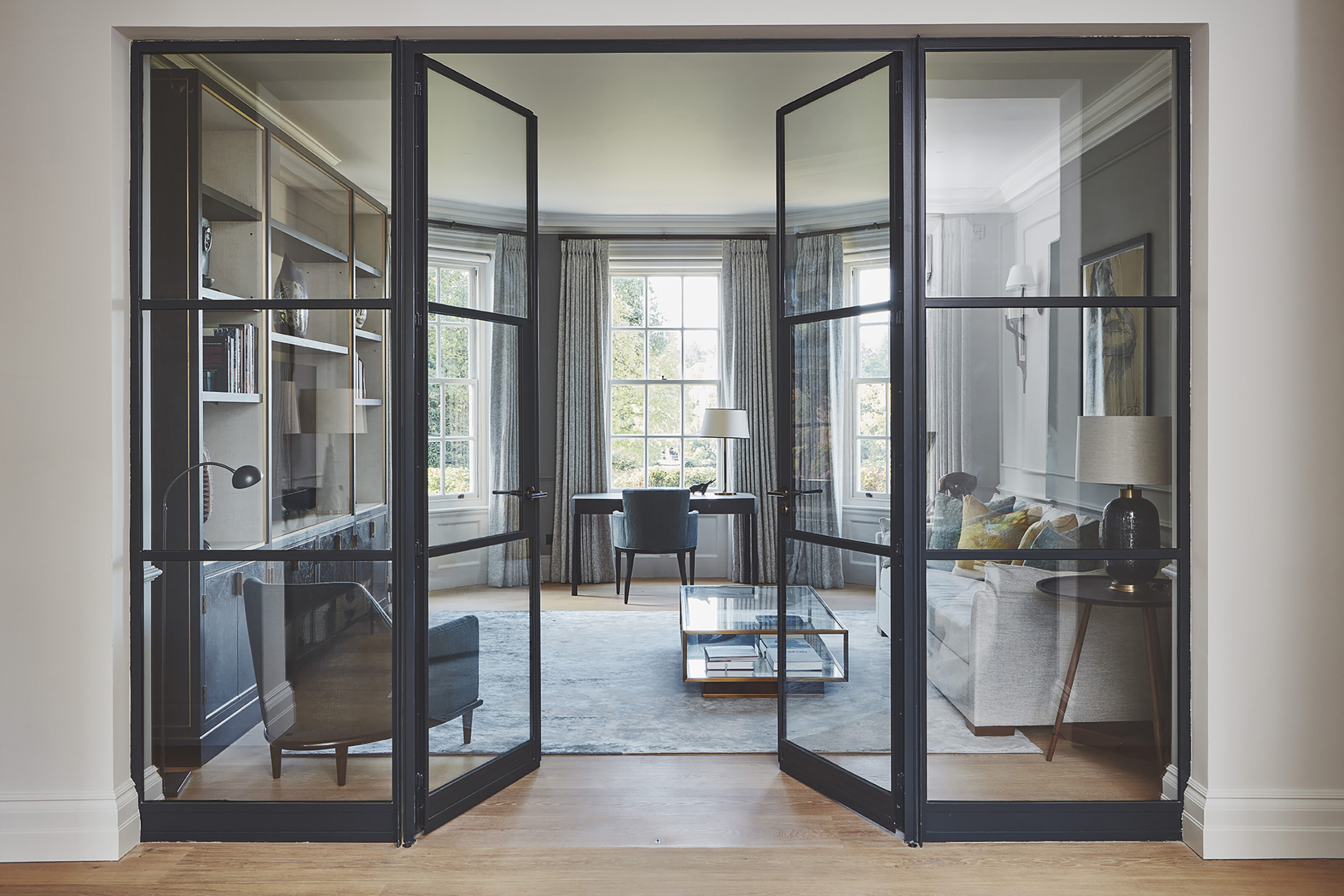 Steel-framed glazed doors opening into a living room within the renovated Edwardian interiors of Westerham House.