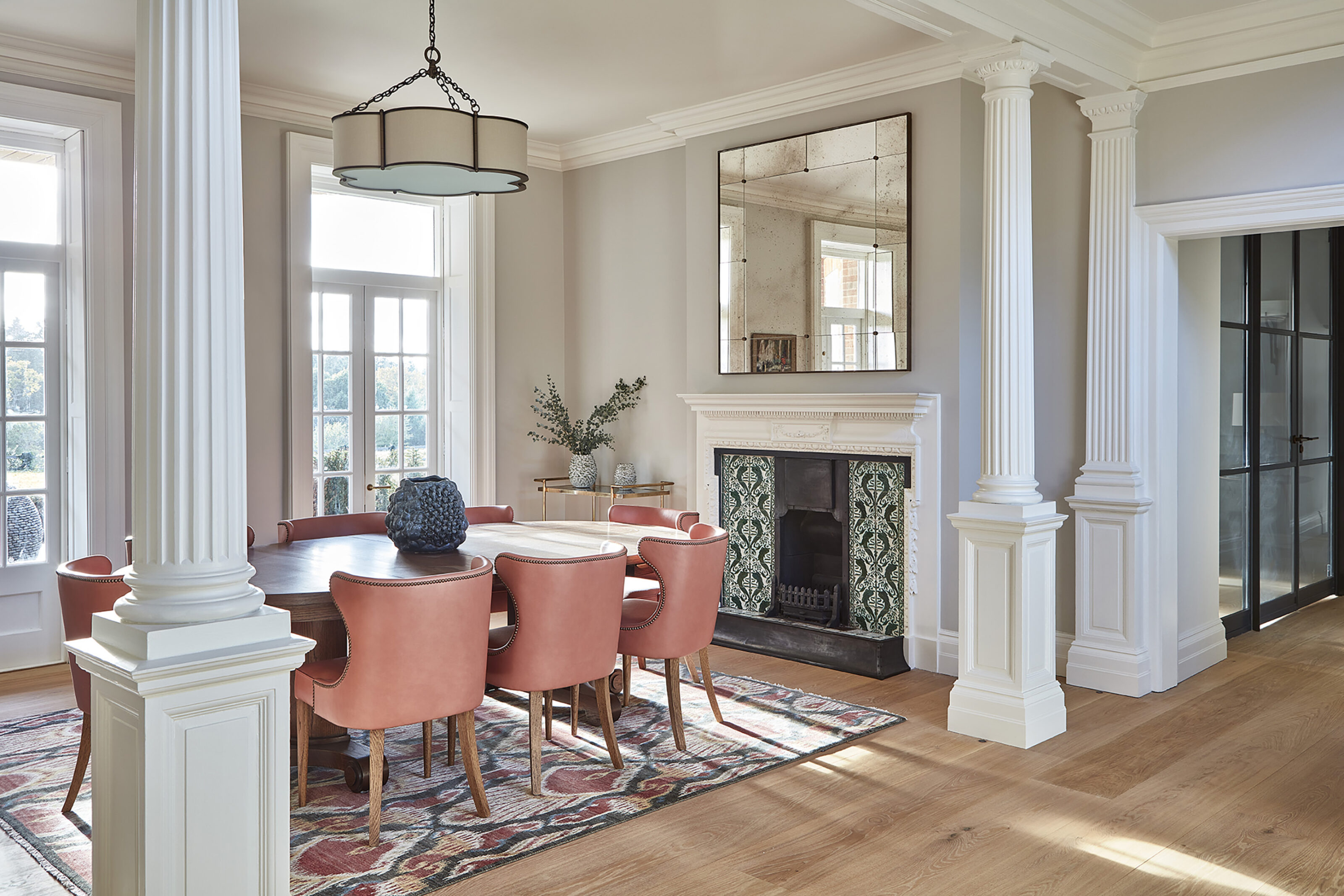 Restored Edwardian dining room at Westerham House featuring original columns, decorative fireplace and contemporary furnishings