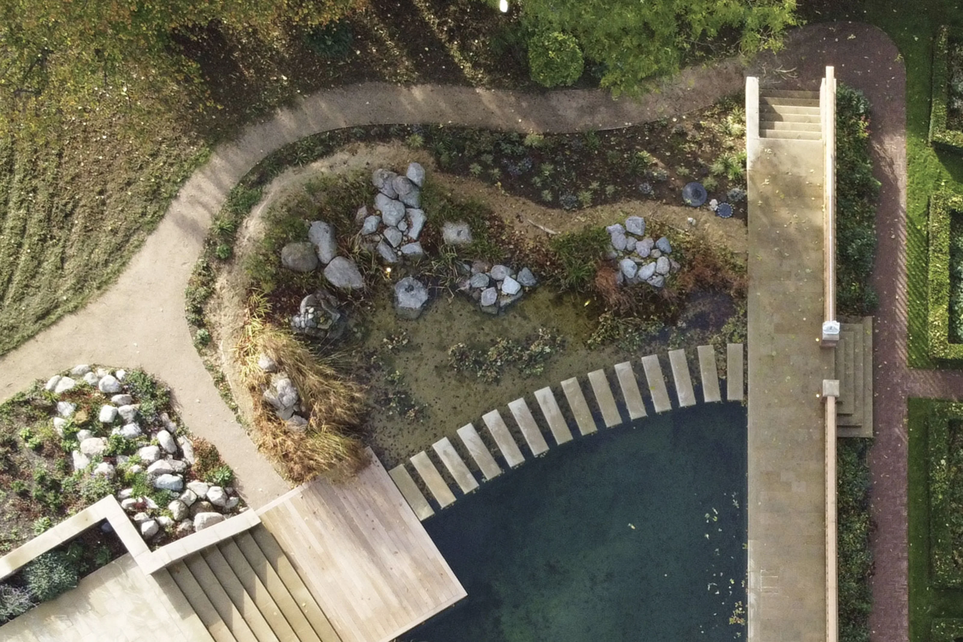 Overhead view of the natural swimming pond, stone planting beds and landscaped terraces at Westerham House.