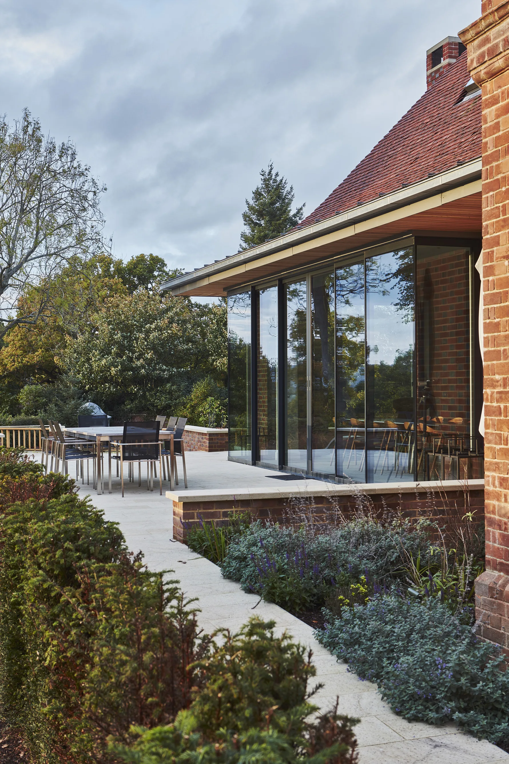 Contemporary kitchen and dining extension at Westerham House with large glazed doors opening onto a landscaped terrace.