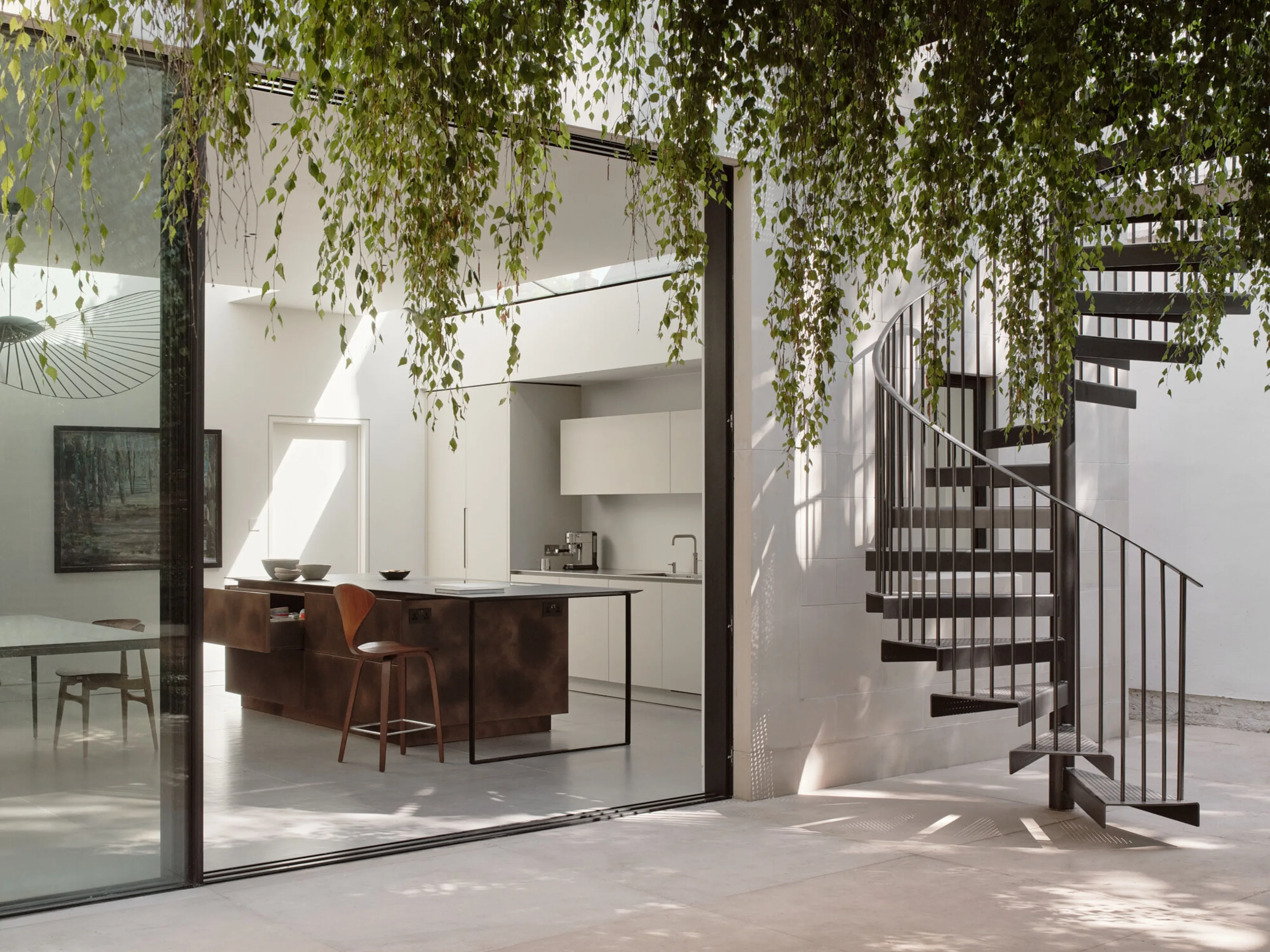 Contemporary kitchen extension with sculptural spiral staircase in renovated Victorian villa in Richmond