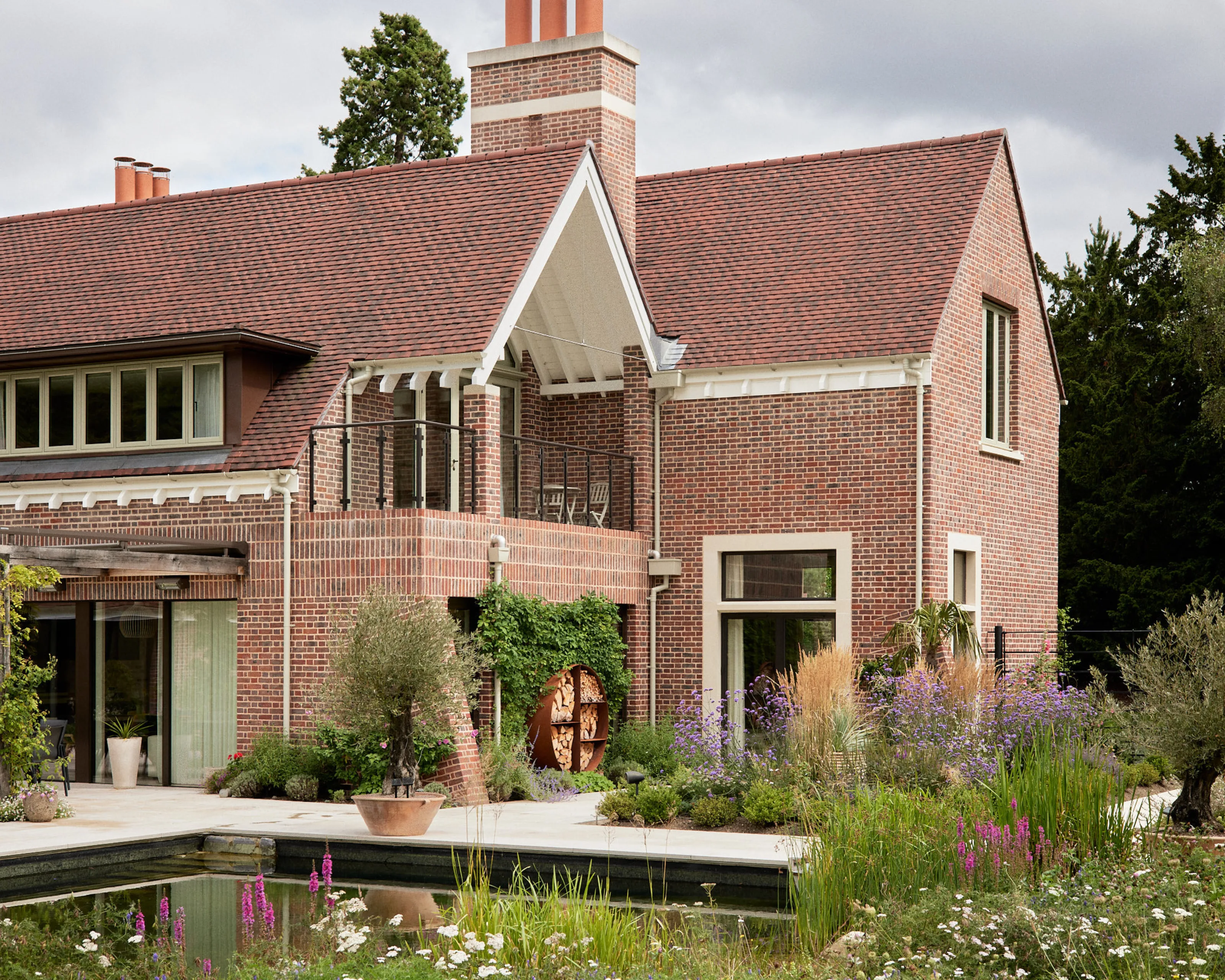 New brick house inspired by Arts and Crafts architecture with swimming pond by Phillips Tracey Architects